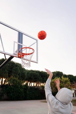 Tanımlanamayan bir adam basketbol potasına top atıyor, sokak sporu kavramı, metin için kopya alanı