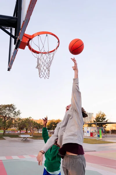 İki genç arkadaş şehir sahasında basketbol oynuyor. Sokaklarda spor kavramı.