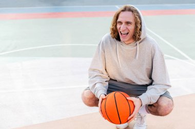 Basketbol oynadıktan sonra sahada gülen beyaz bir adam, şehir sporu konsepti, metin için kopya alanı