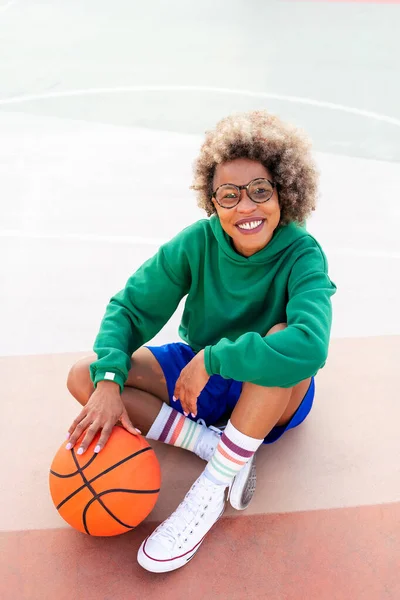 Uśmiechnięta Latynoska Kobieta Patrząca Kamerę Siedzącą Boisku Treningu Koszykówki Koncepcja — Zdjęcie stockowe