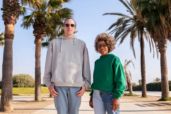 Birkaç arkadaş gülümsüyor. Palmiye ağaçlarının yanındaki kameraya bakıyorlar. Arkadaşlık ve çift ilişkisi kavramı.