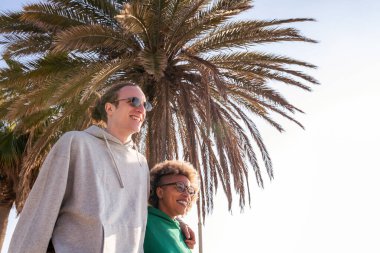 Genç, ırklar arası bir çift yürürken gülümsüyor.