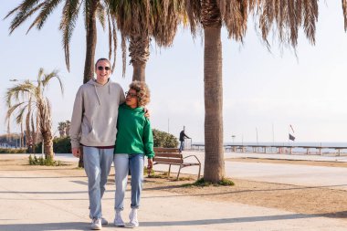 Genç çift yürürken mutlu gülümsüyor.