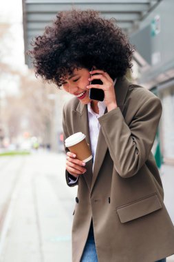 Açık havada konuşan gülümseyen genç Latin kadın, iletişim ve şehir yaşam tarzı kavramı