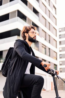 stylish young bearded man riding his bike through the city, concept of urban lifestyle and sustainable mobility, copy space for text