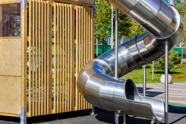 Çocuklar boru şeklinde kayarak kayar. Çelik spiral. Oyun parkı. Eğlence parkı