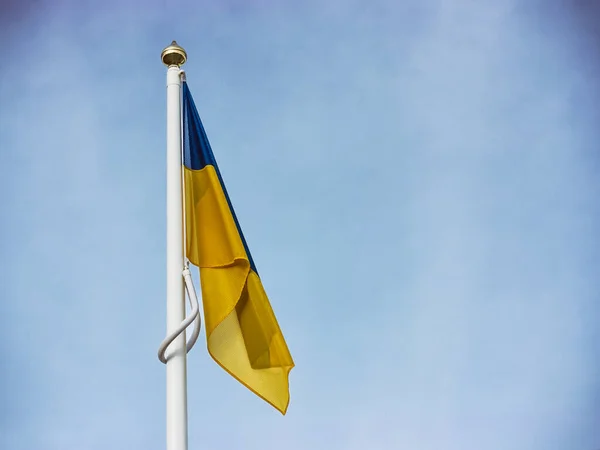 Bandera de Ucrania contra el cielo. asta de la bandera blanca con la bandera de Ucrania — Foto de Stock