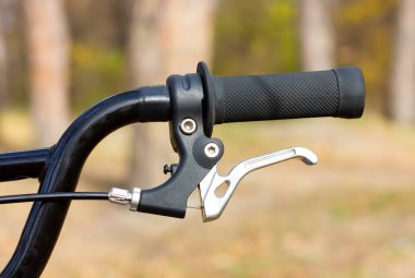 Part of a bicycle handlebar. Hand brakes on a bicycle handlebar.