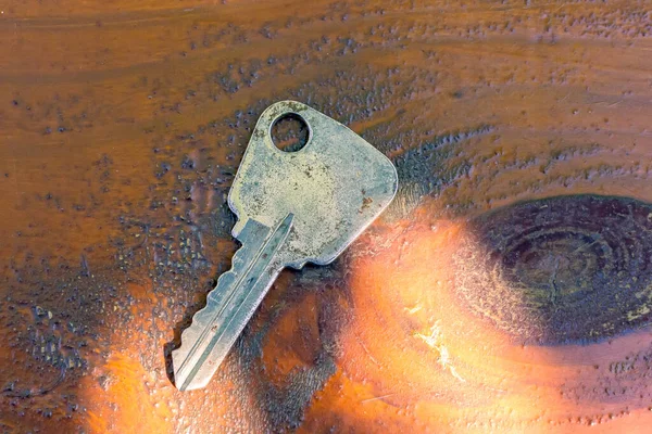 Old-fashioned lock key on a wooden table. Metal key. — Stockfoto