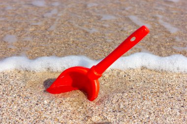 Deniz kıyısındaki kumda kırmızı kürek. Kumsalda tatil..