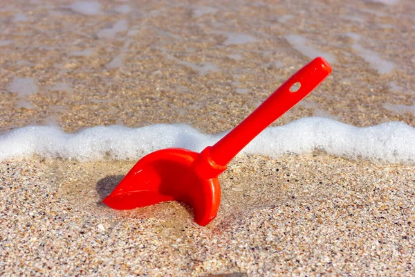 Deniz kıyısındaki kumda kırmızı kürek. Kumsalda tatil..