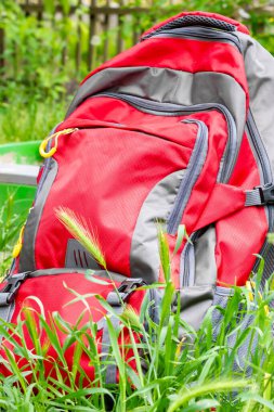 Yeşil çimenlikte büyük kırmızı bir sırt çantası. Boyut çantası. Yüksek kalite fotoğraf