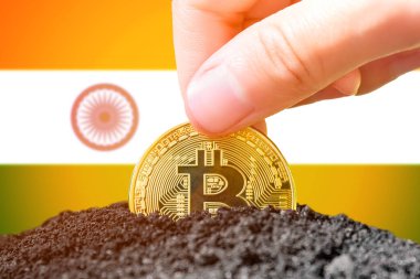 Legalization of bitcoin in India. Landing bitcoin in the ground on the background of the flag of India. India - investment in cryptocurrency. High quality photo