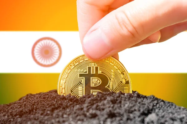 Legalization of bitcoin in India. Landing bitcoin in the ground on the background of the flag of India. India - investment in cryptocurrency. High quality photo