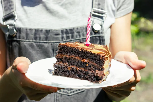 A piece of cake with a blown out candle. A piece of chocolate cake. Candle in chocolate cake. High quality photo