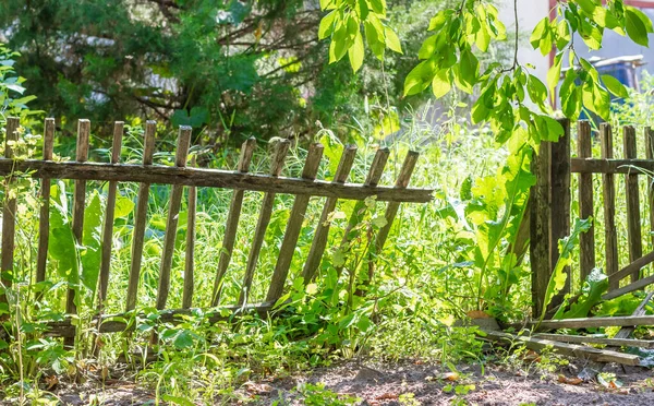 Broken fence. A rickety wooden fence. A breach in the fence. Old wooden fence. High quality photo