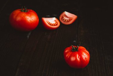 Koyu ahşap masada kırmızı domatesler. Domates hasadı. Kırsal tarzda. Yüksek kalite fotoğraf