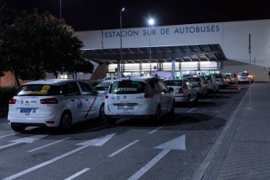 Geceleri Madrid 'in güney otobüs durağındaki taksi parkına park etmiş İspanyol taksiler..