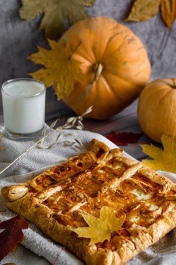 Dikey fotoğraf, natürmort hayat, ahşap zemin üzerinde taze balkabağı turtası ve malzemeler..