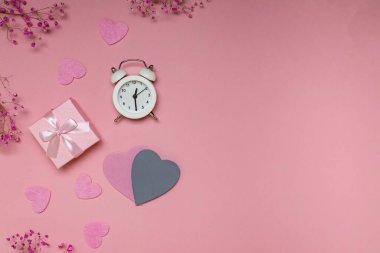 Sevgililer günü için fotokopi alanı olan daire: hediye, çalar saat ve pembe zemin üzerinde kalpler. Yukarıdan görüntüle.