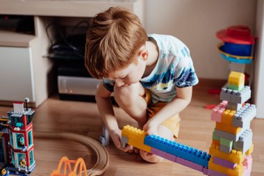 Çocuk kızıl saçlı çocuk anaokulu çocuğu evde tek başına kozturctor oynuyor.