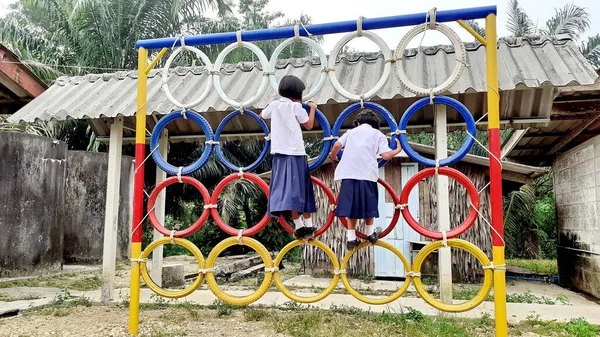 Oyun parkında renkli lastik tekerleklerin üzerinde duran Asyalı bir kızın görüntüsüyle. Kırsal bölgelerde Taylandlı öğrenciler.