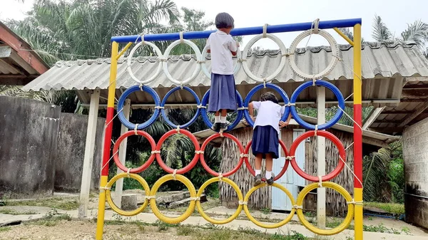 Oyun parkında renkli lastik tekerleklerin üzerinde duran Asyalı bir kızın görüntüsüyle. Kırsal bölgelerde Taylandlı öğrenciler.