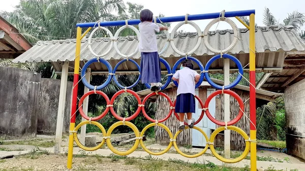 Oyun parkında renkli lastik tekerleklerin üzerinde duran Asyalı bir kızın görüntüsüyle. Kırsal bölgelerde Taylandlı öğrenciler.
