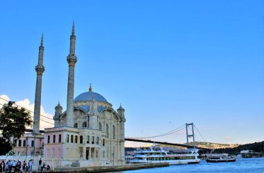 İstanbul Boğazı 'ndaki İstanbul Köprüsü ve feribot geçmişli görkemli Ortakoy camii manzarası, Türkiye.