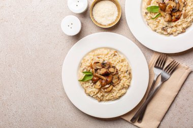 Taştan bej masa üzerinde mantar ve taleggio peyniri karışımlı risotto. İki porsiyon. Üst Manzara. Boşluğu kopyala.