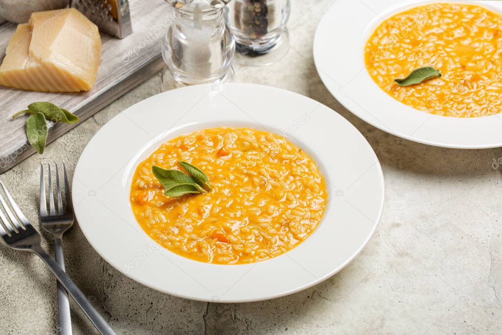 Risotto with pumpkin, taleggio cheese, decorated with sage leaves. Copy space.