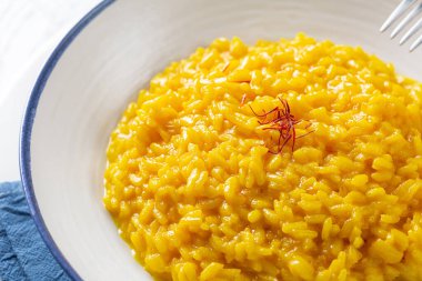 Risotto allo Zafferano. Safran, pirinç ve sebze suyundan yapılmış İtalyan yemeği. Yakın plan..
