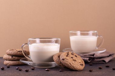Hindistan cevizi sütlü kapuçino ve deve rengi arka planda çikolatalı kurabiye..