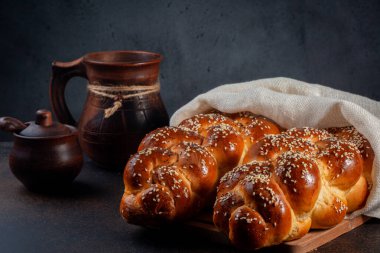 Beyaz kapaklı ev yapımı Challah ekmeği. Ana malzemeler yumurta, beyaz un, su, şeker, tuz ve mayadır. Susam ve haşhaş tohumlarıyla süslenmiş. Koyu arkaplan.