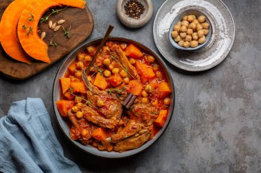 Balkabağı, kuzu eti ve tarçın çubuklu nohut güveci. Gri tablo yüzeyi, üst görünüm.