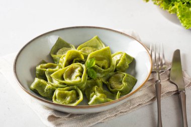 Ev yapımı tortelli ile akşam yemeği - İtalyan yeşil makarna ricotta ve ıspanakla dolu. Hafif arkaplan. 