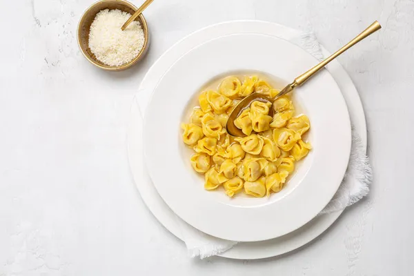 Tortellini İtalyan makarnası et, parmesan peyniri, yumurta ve hindistan cevizi karışımı ile doldurulmuş ve capon çorbası ile servis edilmiş.. 