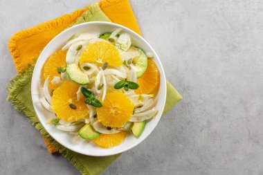 Portakal, rezene ve avokado salatası. Gri arka plan. Üst Manzara. Boşluğu kopyala.