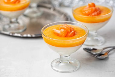 Vanilyalı mandalina, mandalinalı panna cotta, kaynamış krema ve mandalina reçelinden yapılmış tatlı jöle. Yakın çekim, seçici odaklanma.