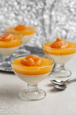 Vanilya mandalinalı panna cotta kaynamış krema ve mandalina reçelinden yapılmış tatlı bir jöle. Dikey resim.