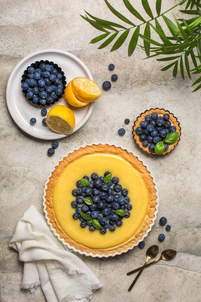 Yaban mersinli ve limonlu tartlı yaz masası. Üst Manzara. Dikey görüntü. Boşluğu kopyala.