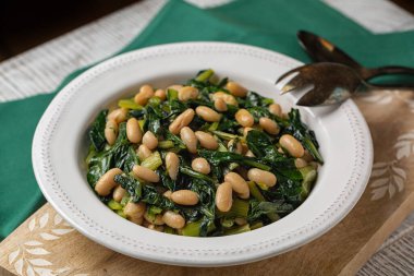 Chicory yapraklarından vejetaryen salatası ve Cannellini fasulyesi veya Cicoria e fagioli, güney İtalya yemeği. Ev yapımı. Sağlıklı yeme kavramı.