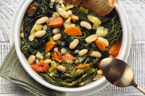 Kızarmış ekmek ve sebzeyle yapılmış Toskana ekmeği çorbası. Ribollita. Cannellini fasulyesi, lacinato lahanası, lahana verzası, havuç, kereviz, patates ve soğan. İtralyan yemeği. Yakın plan. Tam üstte.