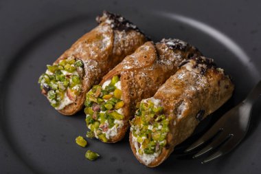 Cannoli Sicilya 'ya yakın. Geleneksel İtalyan tatlısı. İçinde ricotta peyniri kreması ve şam fıstığı ve çikolata var.. 