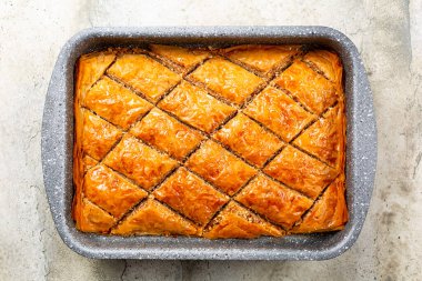 Güveçte Baklava. Filo pastasından yapılmış, doğranmış badem fıstığı ile doldurulmuş ve şurup veya bal ile tatlandırılmış hamur tatlısı. Ev yapımı..
