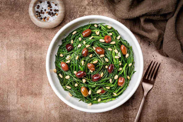 Sauteed Agretti 'li İtalyan salatası ya da sarımsaklı barba di frati, Taggiasca zeytini, pinoli ya da çam fıstığı. En üst tablo görünümü.