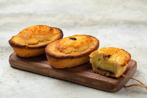 A Pasticciotto, small Italian cake, filled  with egg custard cream. Called also pusties. Traditional pastry in Apulia, South Italy,  typically served for breakfast. Light table surface.