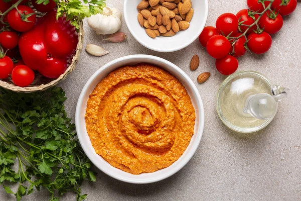 Salsa Romesco ve malzemeler. Domates bazlı İspanyol sebze sosu. Kızarmış domates, kavrulmuş kırmızı dolma biber ve sarımsak, kızarmış badem, zeytinyağı ve ekmekten yapılmış. Tam üstte.