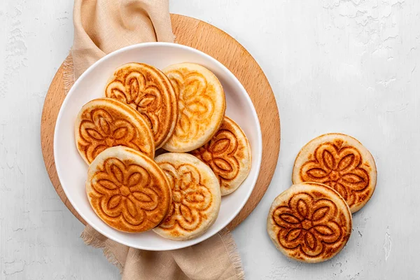 Crescentine, crescente or tigelle. Thin round breads from the Emilia-Romagna, Northern Italy. They are made from flour, water, salt, and yeast. White table surface.