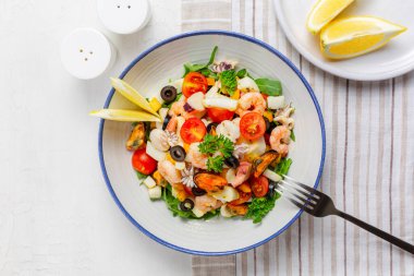 İtalyan karışık deniz ürünleri salatasının en iyi manzarası. Kısrak salata. Kalamar, karides, istiridye, domates, dolmalık biber, maydanoz ve zeytin. Beyaz tablo yüzeyi